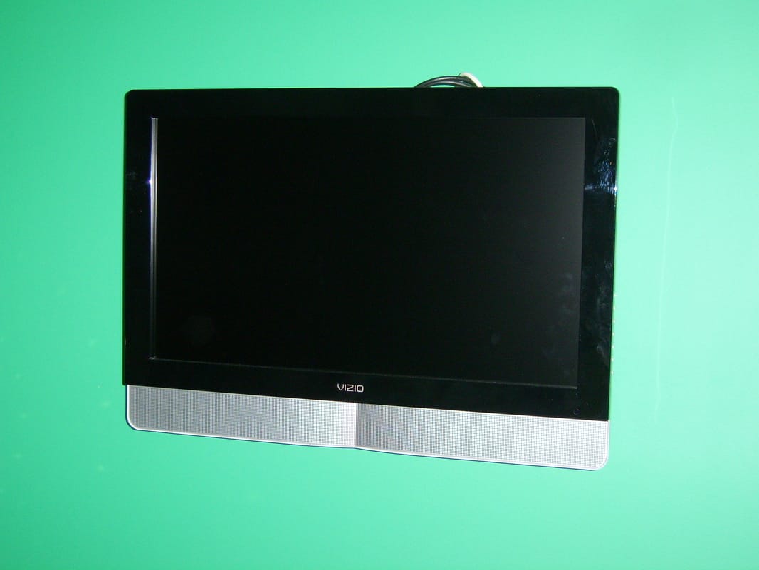 Flat-screen TV mounted on a wall with the cable and power moved behind it